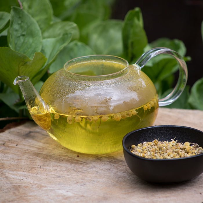 Kopje biologische kamillethee gemaakt van gedroogde kamillebloemen